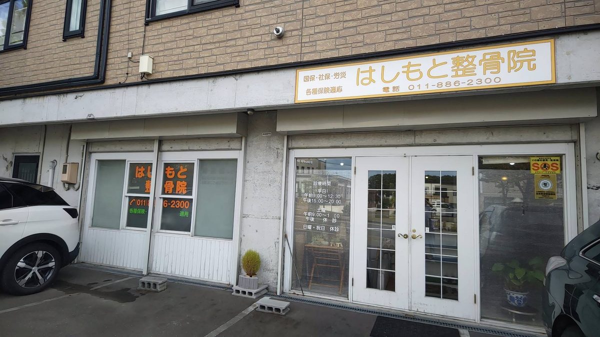はしもと整骨院の外観。黄色い看板と白い入口ドア